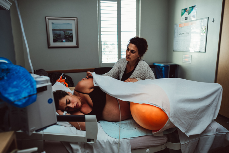 Birth Photography - woman in labor is comforted by her mother at the hospital