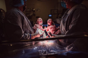 two babies are lifted after twin cesarean birth