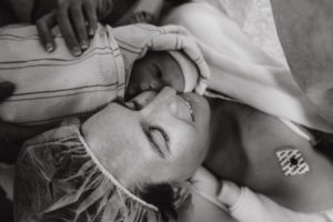 mother holds newborn close to face after cesarean birth