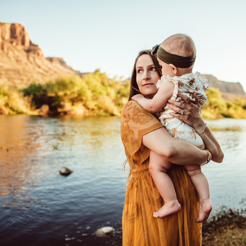 Family Photographer, mother holding baby next to a river